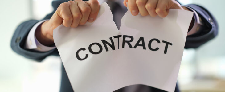 Businessman in suit tearing up job contract in office closeup. Termination of contracts and transactions concept