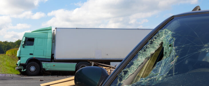 View of truck in an accident with car, cloudy sky